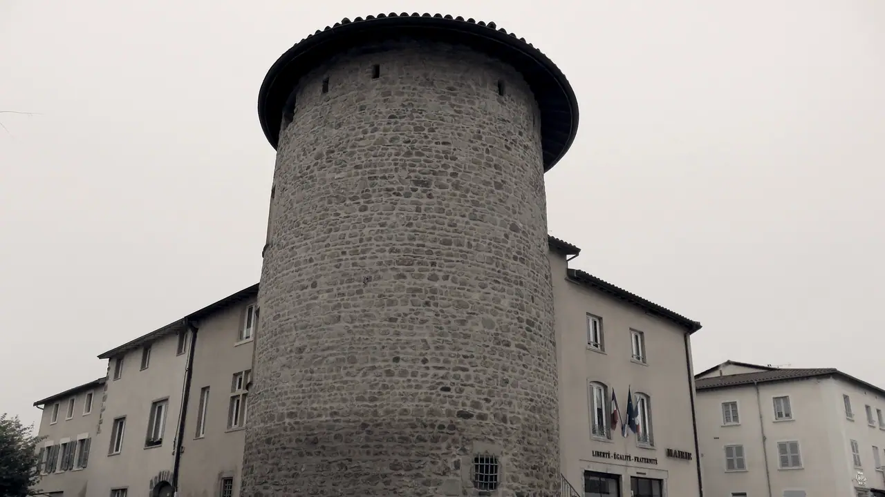 Tour ronde en pierre de l'ancien château de Brindas, coiffée d'un toit de tuiles débordant, accolée à la mairie, avec deux drapeaux sur la façade.