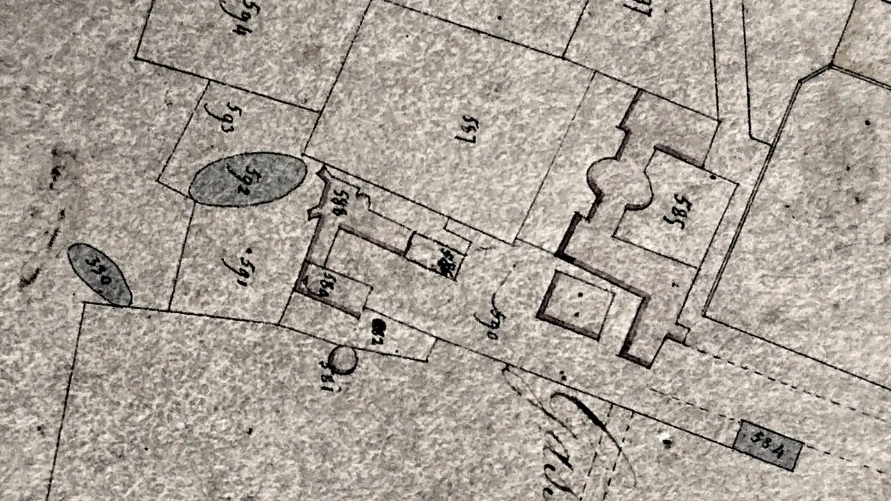 Extrait d'un plan cadastral ancien dessiné à la main, avec des parcelles numérotées et le tracé de bâtiments et d'un chemin.