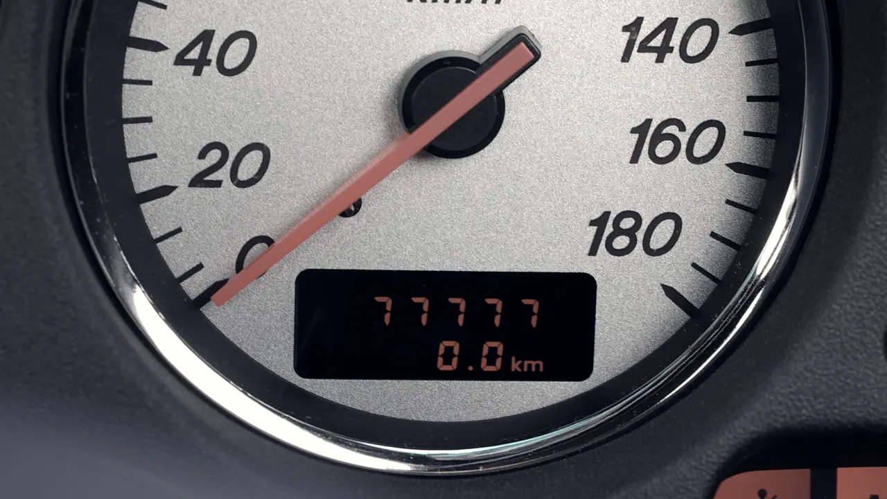 Compteur de vitesse d'automobile : sous l'aiguille au repos, un totaliseur à roues chiffrées et un compteur journalier remis à zéro.