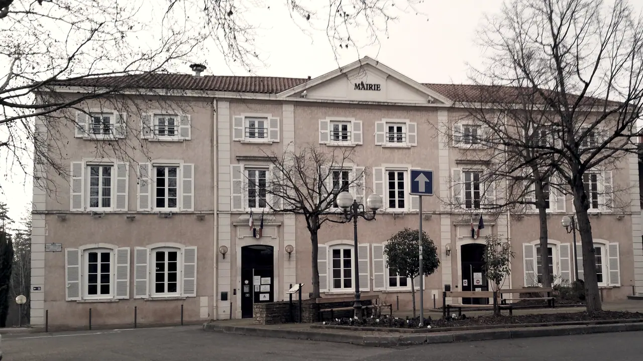 Mairie de Charbonnières-les-Bains : façade à deux étages aux volets clairs, sous un fronton marqué « Mairie », derrière des arbres nus et deux bancs sur une place.
