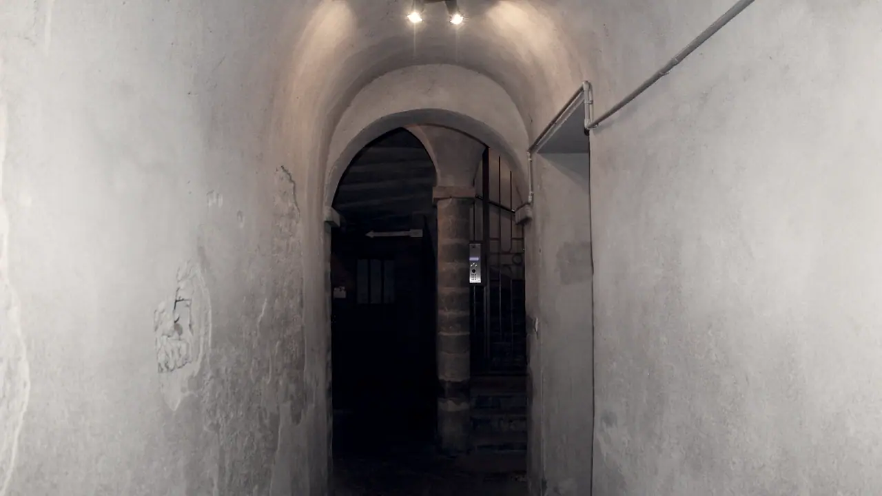 Traboule du Vieux Lyon : un passage voûté sombre traverse un immeuble et débouche sur la lumière, au fond.