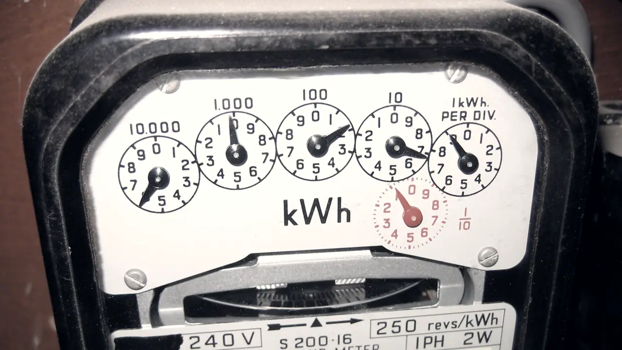 Cadran d'un compteur électrique mécanique, avec cinq aiguilles sur cinq petits cadrans à lire ensemble sous la mention kWh.