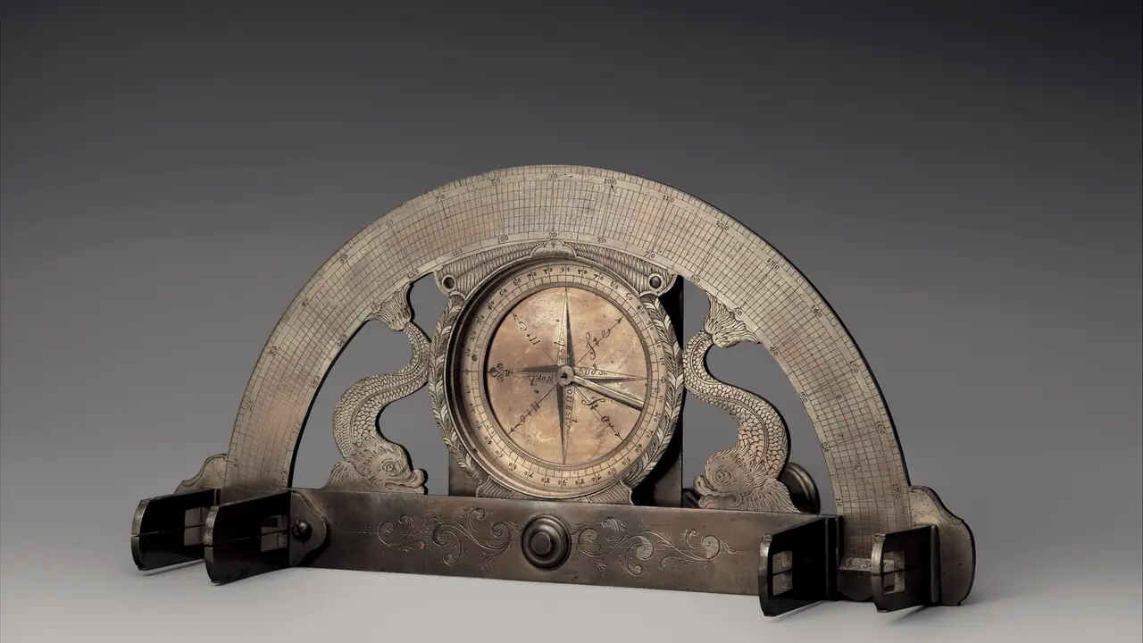Graphomètre ancien en laiton gravé : un demi-cercle gradué posé sur une règle à pinnules, avec une boussole au centre entre deux dauphins ciselés.