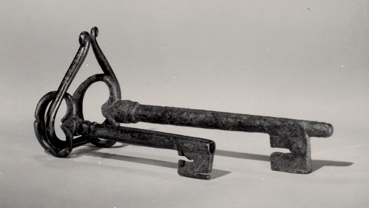 Deux clés anciennes en fer posées côte à côte sur un fond neutre, avec des pannetons aux découpes différentes.